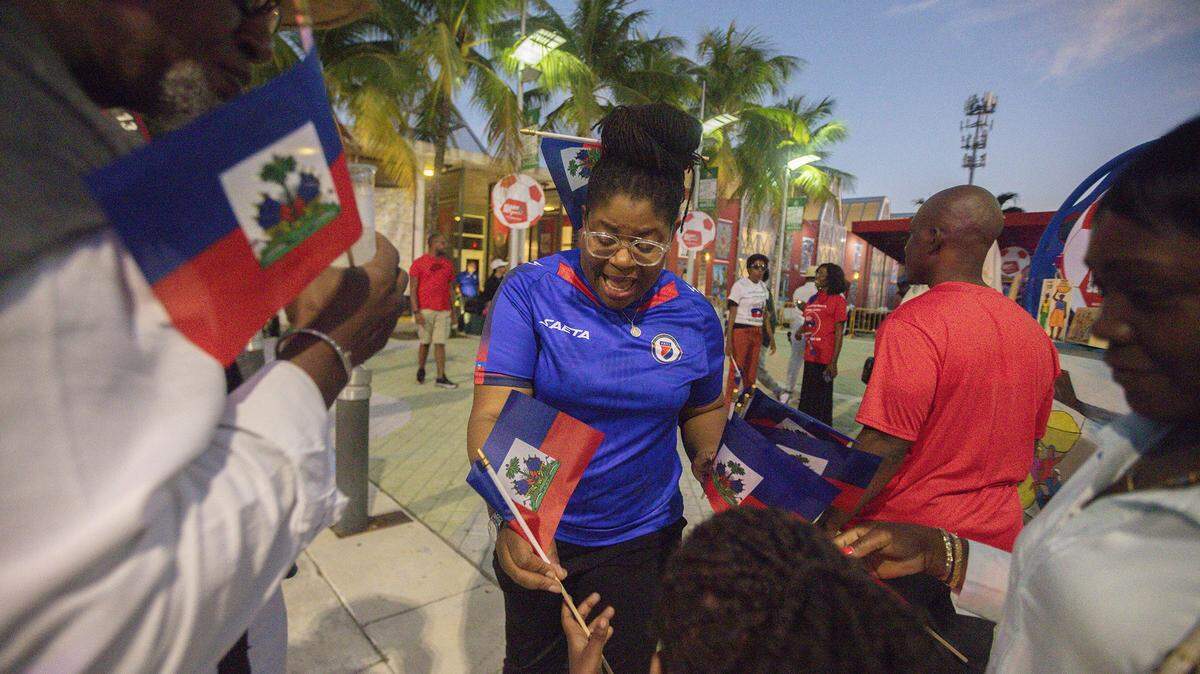 Sandy Dorsainvil shares Haitian flags during the Haitian World Cup Block Party at the Little Haiti Cultural Center in Little Haiti on Saturday, November 22, 2025.  The event celebrated Haiti qualifying for the World Cup.