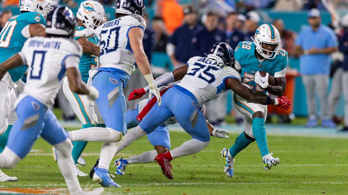 Miami Dolphins running back De’Von Achane (28) is tackled by Tennessee Titans safety K’Von Wallace (35) in the second quarter of their NFL game at Hard Rock Stadium on Monday, Dec. 11, 2023, in Miami Gardens, Fla.
