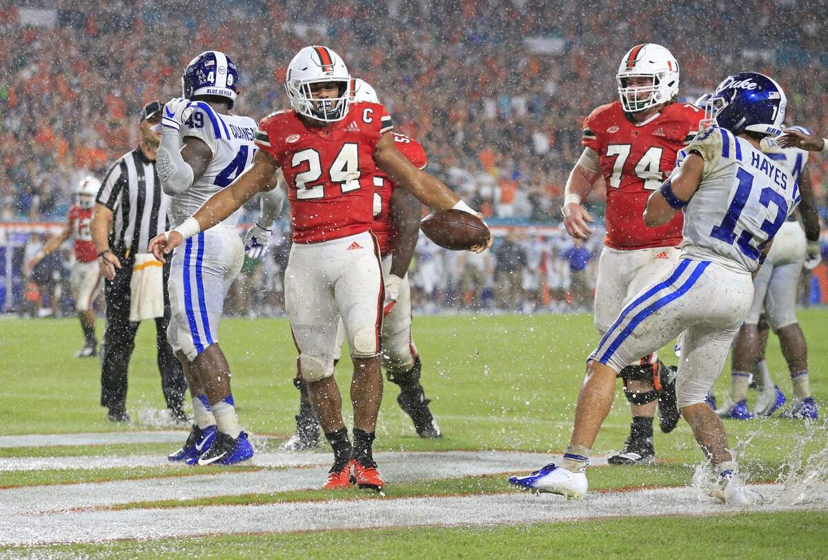 Miami Hurricanes running back Travis Homer (24) scores during a downpour in the second quarter as the University of Miami host Duke University at Hard Rock Stadium in Miami Gardens on Saturday, Nov. 3, 2018.