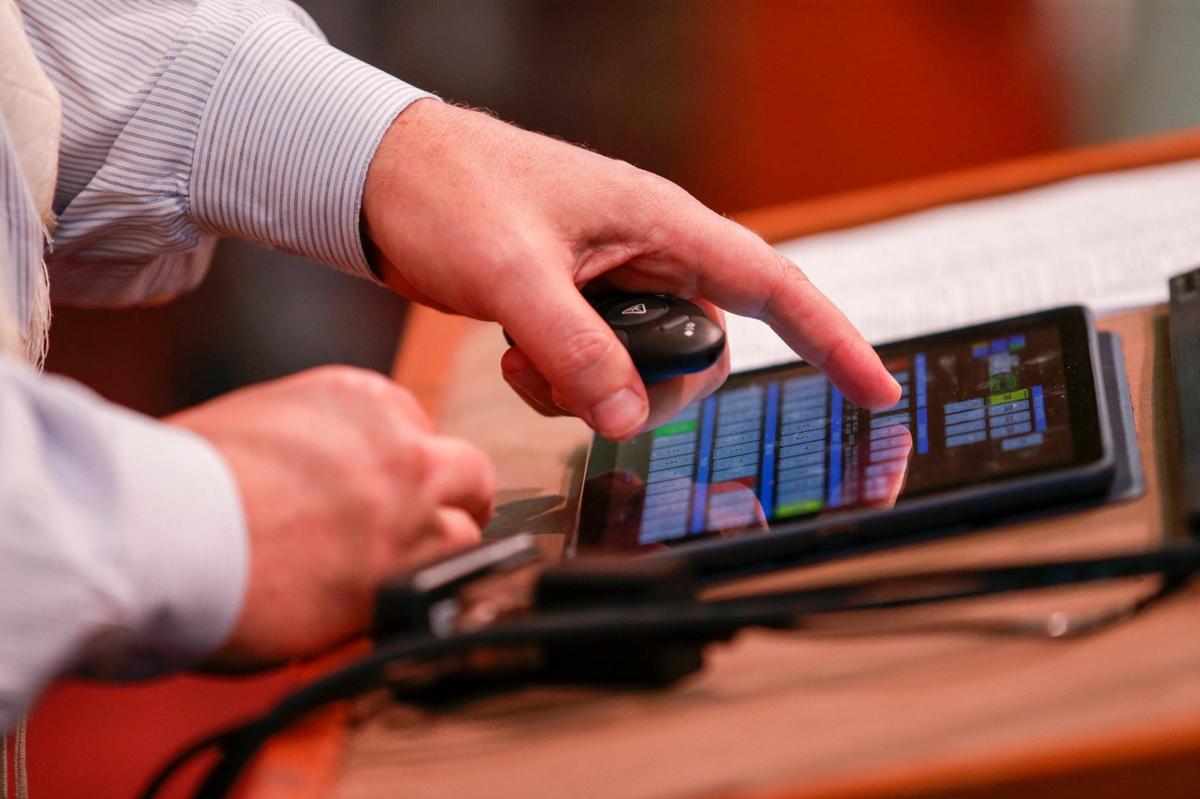 Rabbi Alan Litwak uses a tablet to control the screens and graphics showing on TVs Aug. 27, 2021, during an online service for worshipers to stream live from home as the Temple Sinai of North Dade prepares for the Jewish High Holidays services in times of Covid-19.