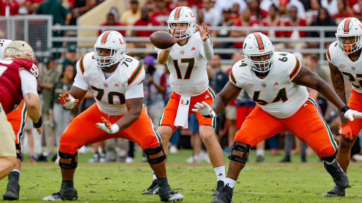 Miami Hurricanes quarterback Emory Williams (17) takes a snap as offensive linemen Javion Cohen (70) and Jalen Rivers (64) block during the game against the Florida State Seminoles during the first half at Doak Campbell Stadium in Tallahassee on Saturday, November 11, 2023.