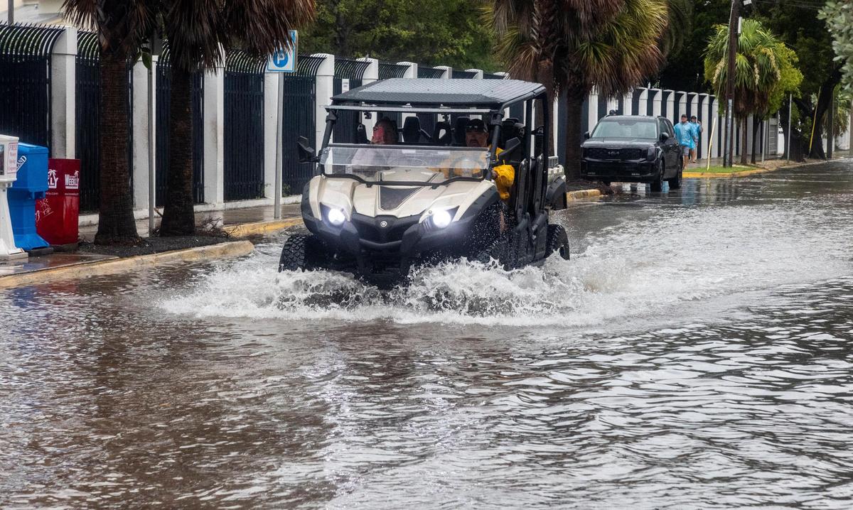 An all terrain vehicle plows moves through high water at the Southernmost Point marker in Key West, on Tuesday, Sept. 27, 2022. Key West has been experiencing bands of rain and high wind followed by period of relative calm as Hurricane Ian moves closer to Florida.