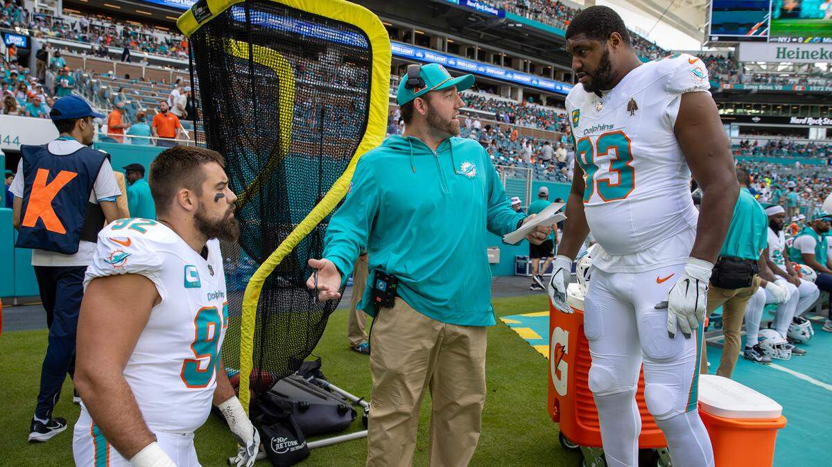 Miami Dolphins defensive line coach Austin Clark speaks with defensive tackles Zach Sieler (92) and Calais Campbell (93) prior to the team’s NFL game against the New York Jets at Hard Rock Stadium, Sunday, Dec. 8, 2024, in Miami Gardens, Florida.