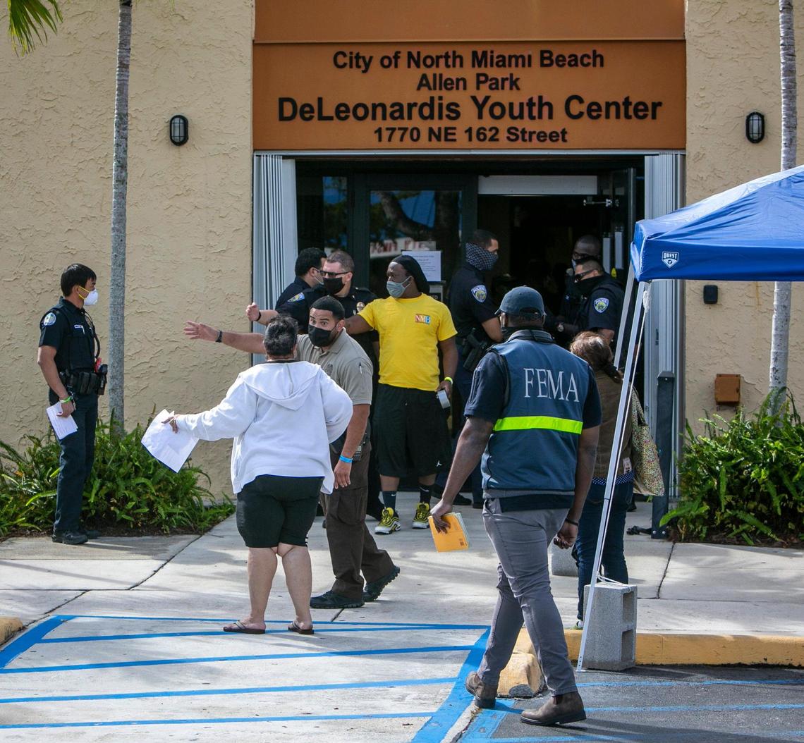 A policeman gives instructions to a woman in front of the Allen Park Community Center, 1770 NE 162nd Street, North Miami Beach, one of two new satellite federal vaccination sites opening on Thursday. The other one opened in Miami Springs.