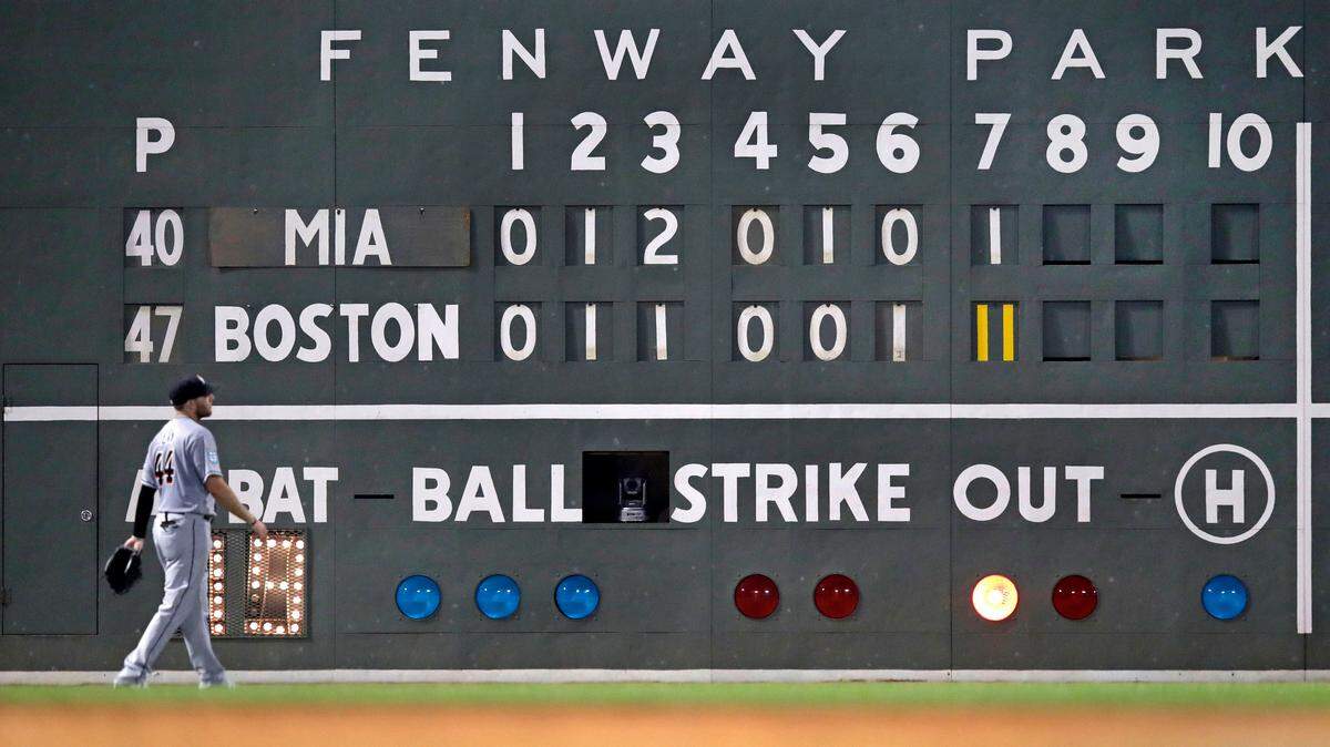 Miami Marlins left fielder Austin Dean walks back to his position during an 11-run seventh inning by the Boston Red Sox during a baseball game at Fenway Park in Boston, Wednesday, Aug. 29, 2018. (AP Photo/Charles Krupa)