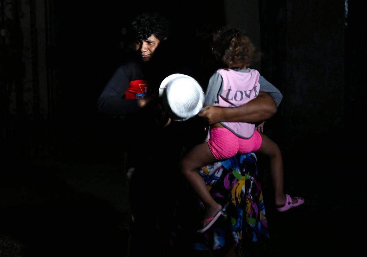 Los cubanos golpean cazuelas para exigir electricidad durante la tercera noche de un apagón nacional en La Habana el 20 de octubre de 2024.