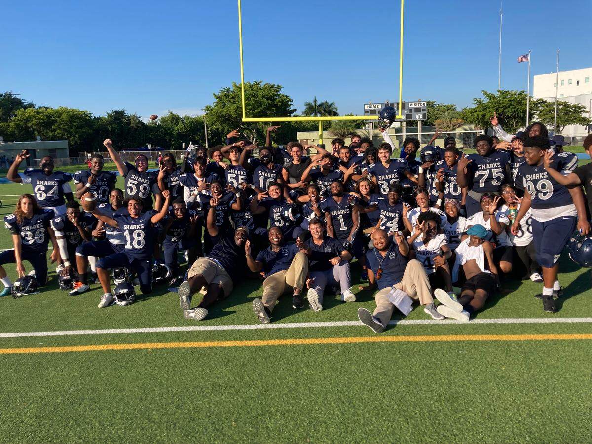 Players and coaches from Alonzo and Tracy Mourning High’s football team celebrate after ending a 41-game losing streak on Friday against Miami Country Day at North Miami Stadium.