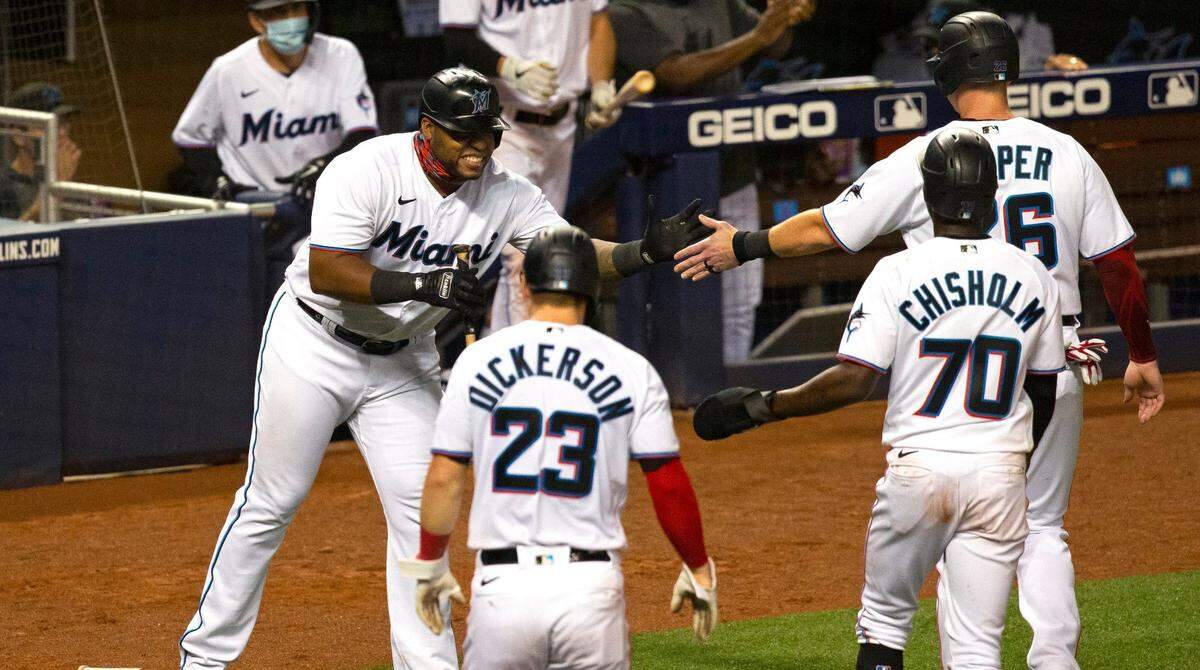 Miami Marlins first baseman Jesus Aguilar (24) congratulates teammates Corey Dickerson (23) Jazz Chisholm (70) and Garrett Cooper (26) after scoring on three run RBI double by Starling Marte (6) during a baseball game against the Philadelphia Phillies at at Marlins Park in Miami on Thursday, September 10, 2020.