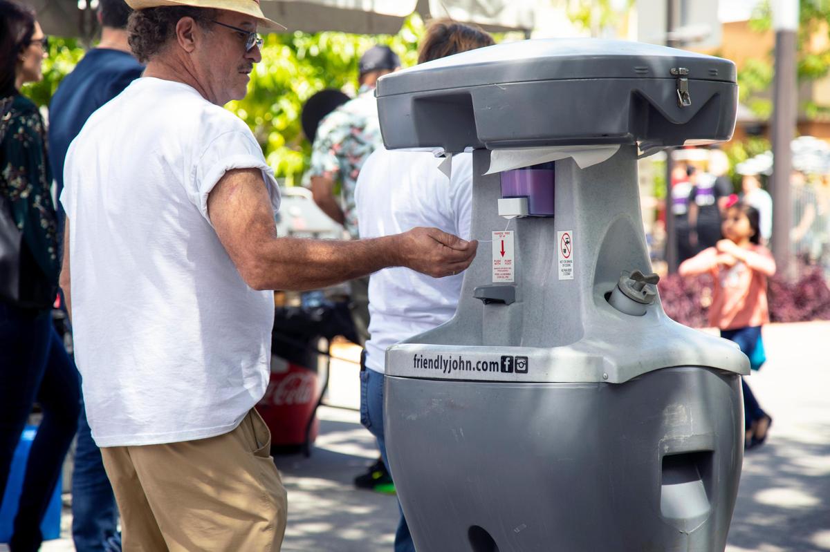 A man uses a portable sanitization station during Carnaval on the Mile at Miracle Mile in Coral Gables, Florida on Saturday, March 7, 2020. Despite cases being reported in South Florida attendees are generally unfazed and continue on with their weekend plans.