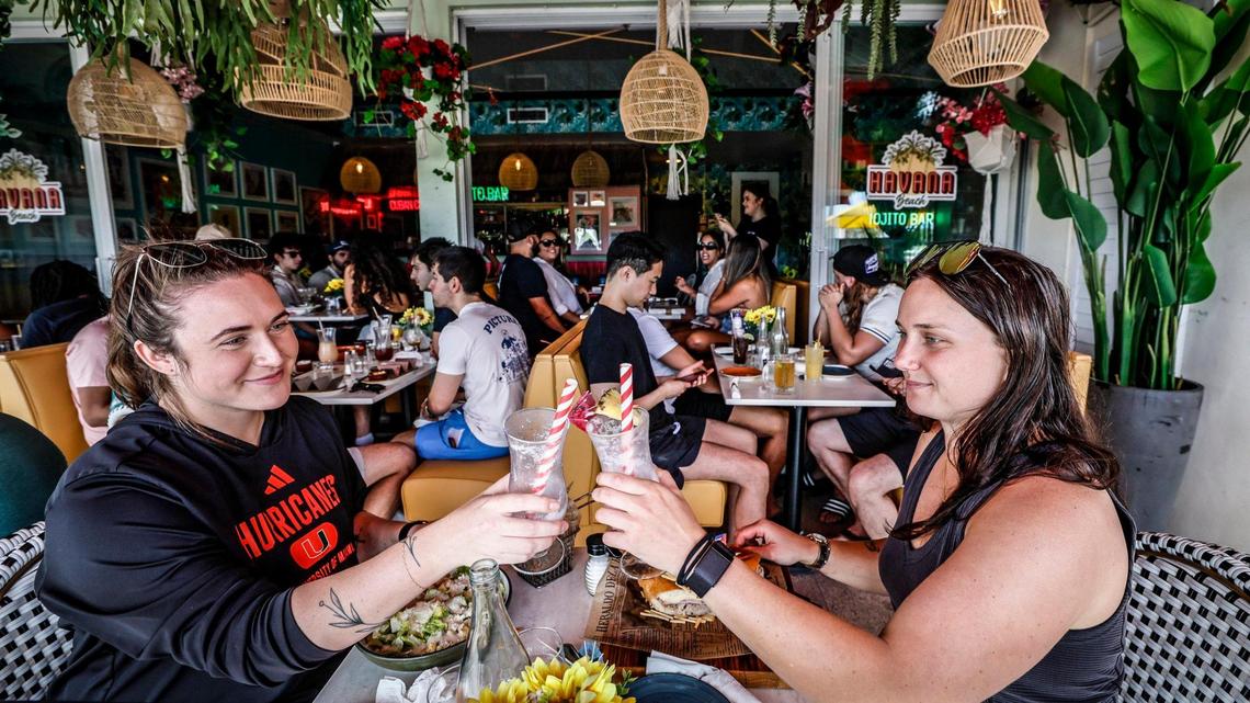 Teachers on spring break, Hannah Bernick and Bethaney Keen of Sarasota, left to right, toast while drinking cocktails at Havana Beach Restaurant at the Boulevard Hotel along Ocean Drive on Miami Beach, Florida on Saturday, March 15, 2025.