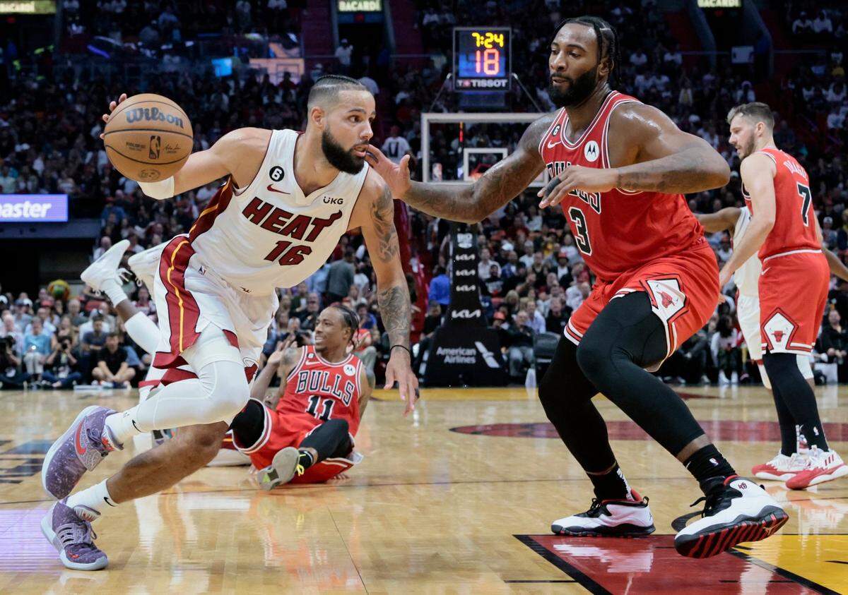 Miami Heat forward Caleb Martin (16) drives the ball as Chicago Bulls center Andre Drummond (3) defends in the second half at FTX Arena on Wednesday, October 19, 2022.