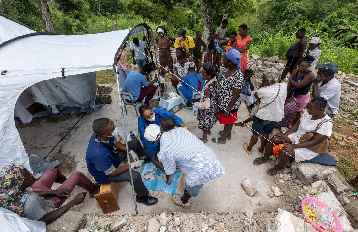 Haitians wait patiently outside a small tent installed by a group of volunteer Haitian doctors who recently finished medical school and have come to Marceline, Haiti to help victims of the Aug. 14, 2021 deadly earthquake.