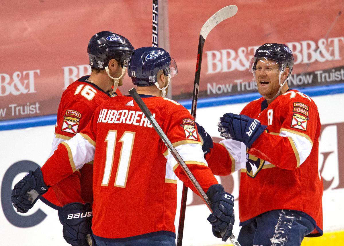 Florida Panthers left wing Jonathan Huberdeau (11) is congratulated by teammates Aleksander Barkov (16) Patric Hornqvist (70) after scoring against the Chicago Blackhawks during the third period of the Florida Panthers NHL home opener game at the BB&T Center on Sunday, January 17, 2021 in Sunrise, Fl.