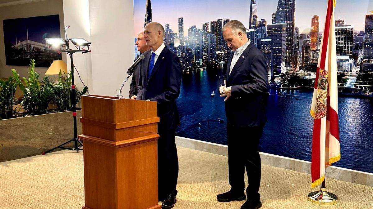 Representatives Carlos Giménez (left) and Mario Díaz-Balart (right) and Senator Rick Scott during a press conference at Miami International Airport on May 24, 2023.