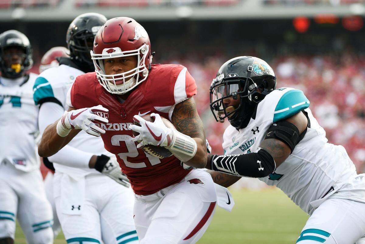 Arkansas running back Devwah Whaley pushes past Costal Carolina defender Eric Church, right, to score a touchdown during the first half of an NCAA college football game Saturday, Nov. 4, 2017, in Fayetteville, Ark. (AP Photo/Michael Woods)