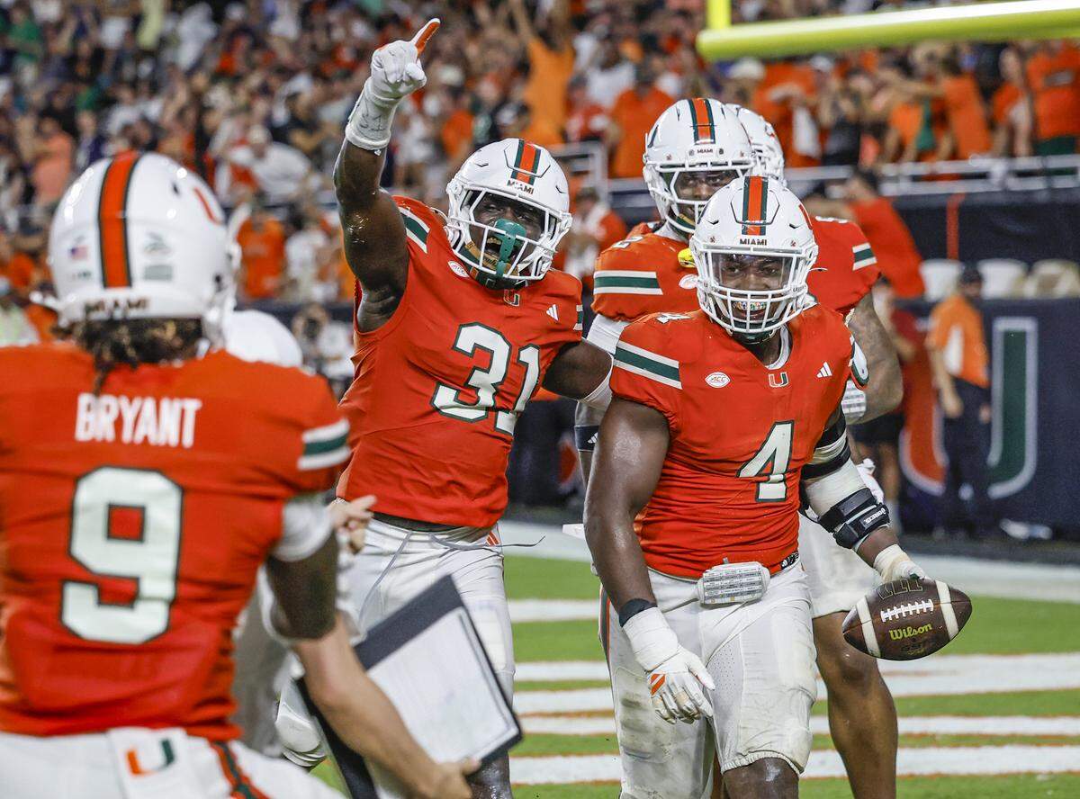 Miami Hurricanes defensive lineman Rueben Bain Jr. (4) celebrates with teammates after  intercepting the ball in the fourth quarter during an NCAA football game Notre Dame Fighting Irish at Hard Rock Stadium in Miami Gardens, Florida, on Sunday, August 31, 2025. 