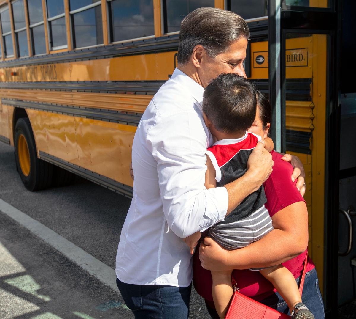 Alberto Carvalho, superintendente escolar de Miami-Dade, saluda a inmigrantes cuando se bajan del autobús escolar para llegar al campamento secreto donde viven en el sur de Miami-Dade. Carvalho persuadió a los padres que era seguro enviar sus hijos a la escuela.