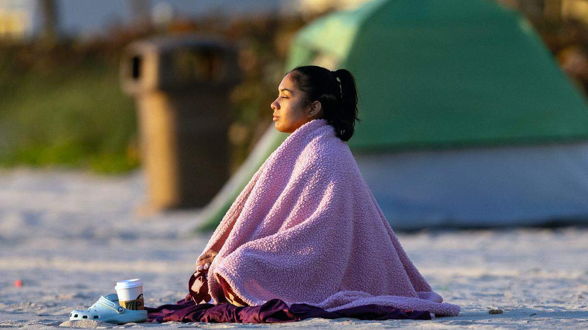 South Florida resident Lorraine Rodriguez taking in the sunrise under the cold weather on Tuesday, Jan. 30, 2024 in Sunny Isles Beach, Florida.