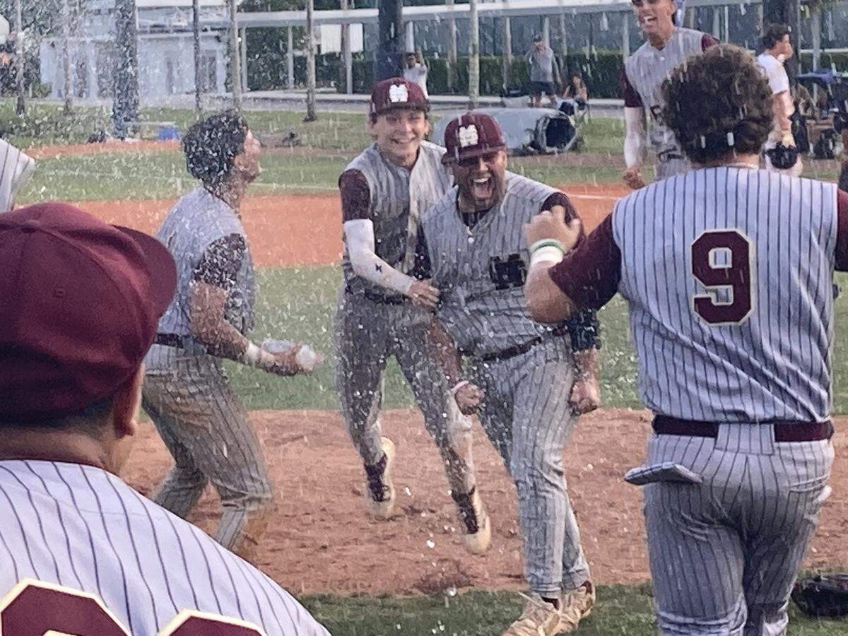Miami Springs pitcher Damian Villabrille is surrounded by his teammates after the final out of the Hawks’ win over Gulliver Prep in the decisive game of the Region 4-3A final on Saturday at Gulliver.