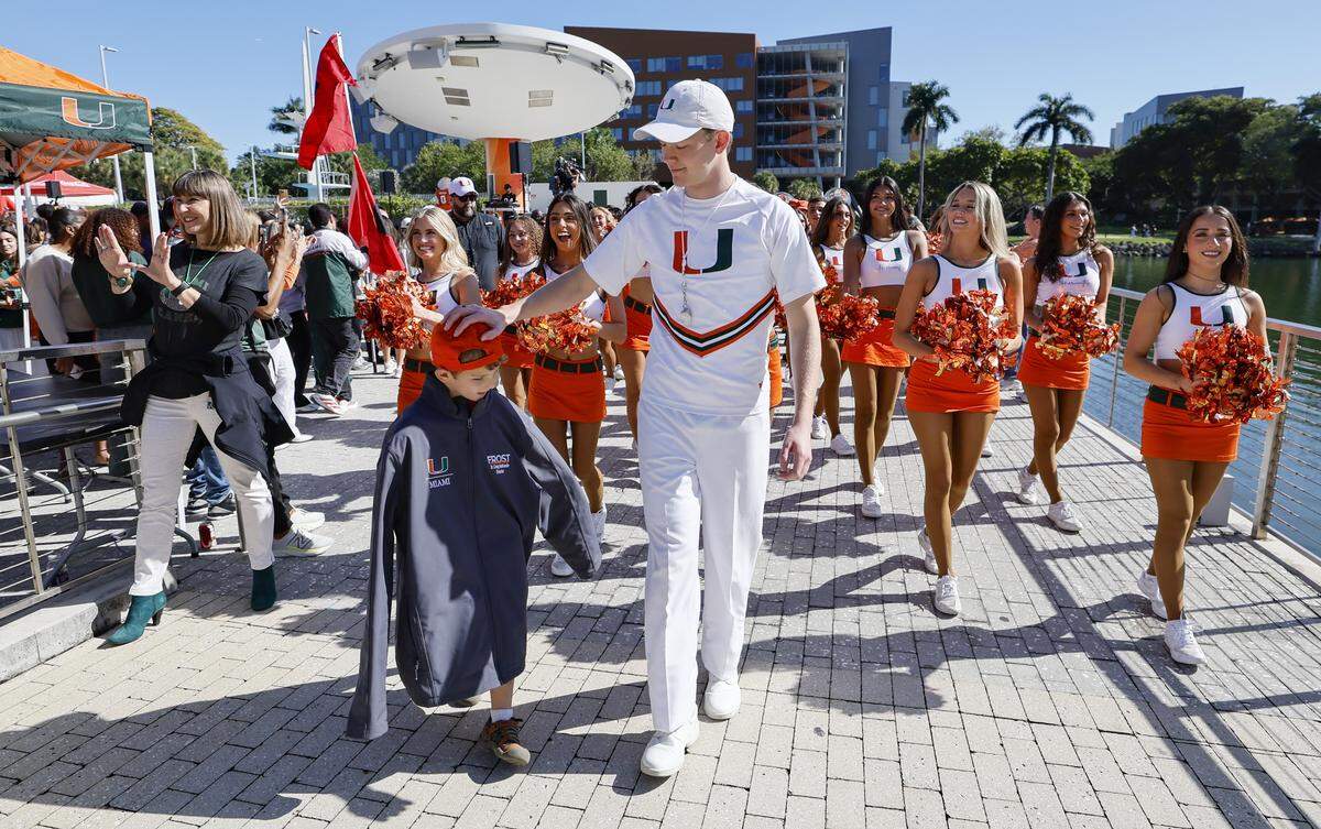 Miami Hurricanes cheerleaders walk with Canes fans during Friday’s campus pep rally.