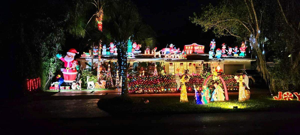The holiday light display at the Detres-Bomke home, 6150 SW 48th St., includes a giant Santa inflatable and many more Santas, along with angels by a nativity scene.