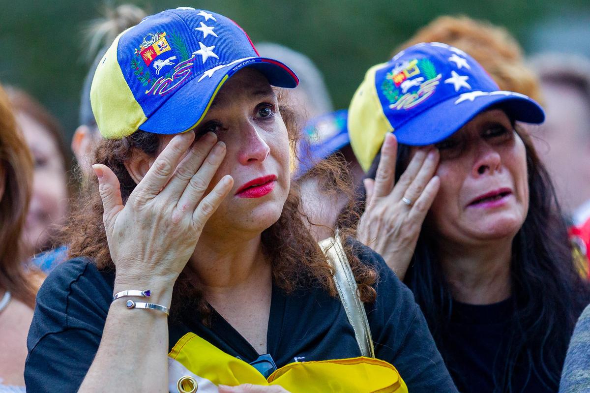 Auristela Sandoval, 52, left, and Dalila Arrarte, 60, cry during a protest in Downtown Doral Park on Wednesday, Jan. 23, 2019.