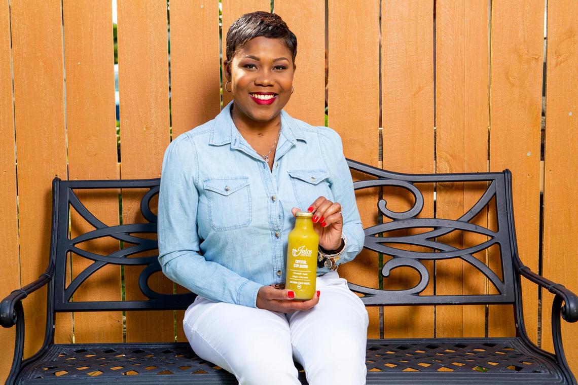 Fathiyyah Doster, owner of juicing company “JuiceDefined,” poses with a bottle of Crystal Explosion for a portrait for the Miami Herald at her home in Miami Gardens, Florida, on Thursday, October 15, 2020.