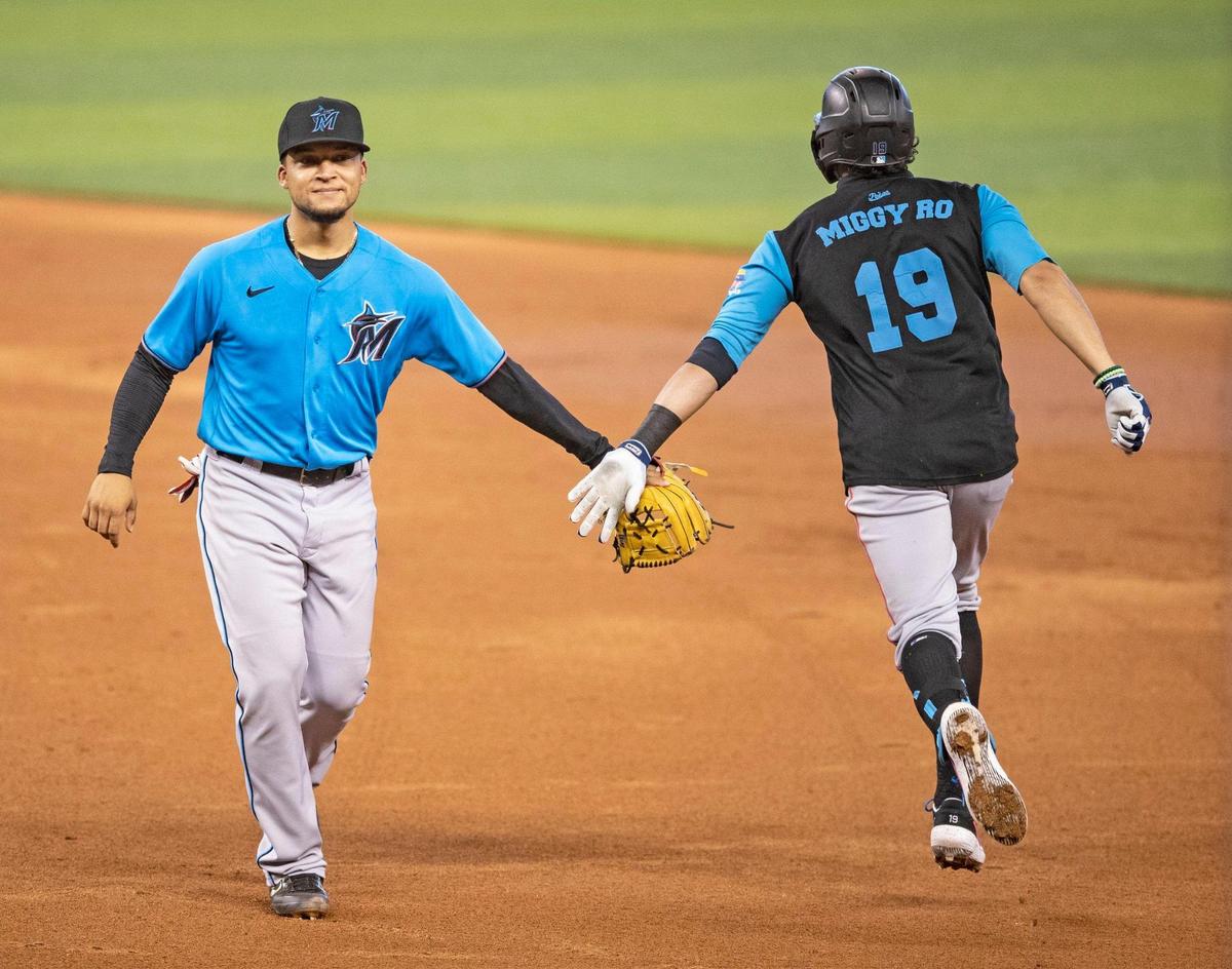 Infielder Isan Diaz reaches out to Miguel Rojas (19) after Rojas hits a home run during Marlins training camp at Marlins Park on Saturday, July 4, 2020.