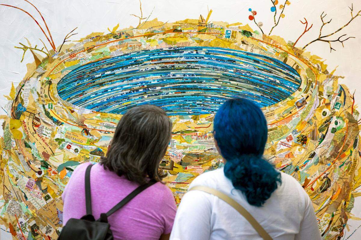 Two festivalgoers look at a piece of art during the 2022 Coconut Grove Arts Festival.