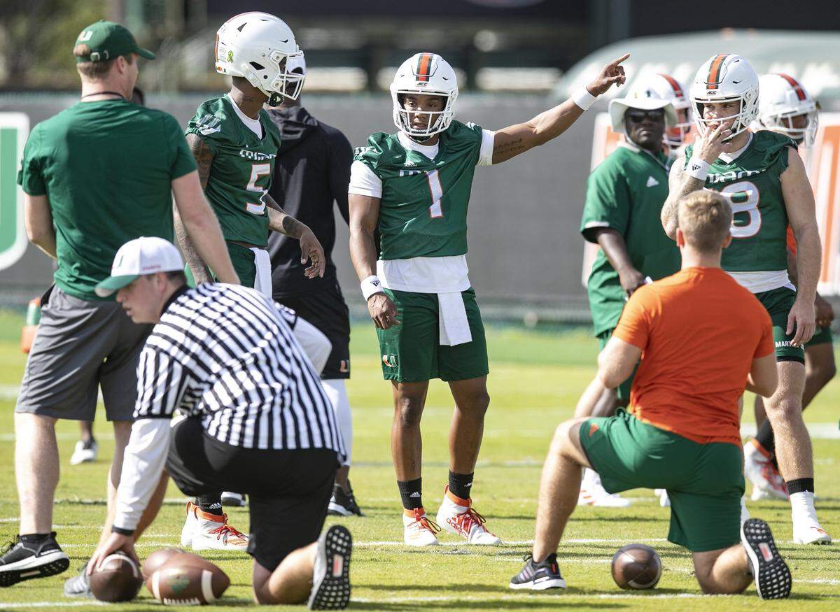 Miami Hurricanes quarterbacks N’Kosi Perry (5), D’Eriq King (1), and Tate Martell (18) run drills during practice at the University of Miami’s Greentree Field in Coral Gables on Monday, March 2, 2020.