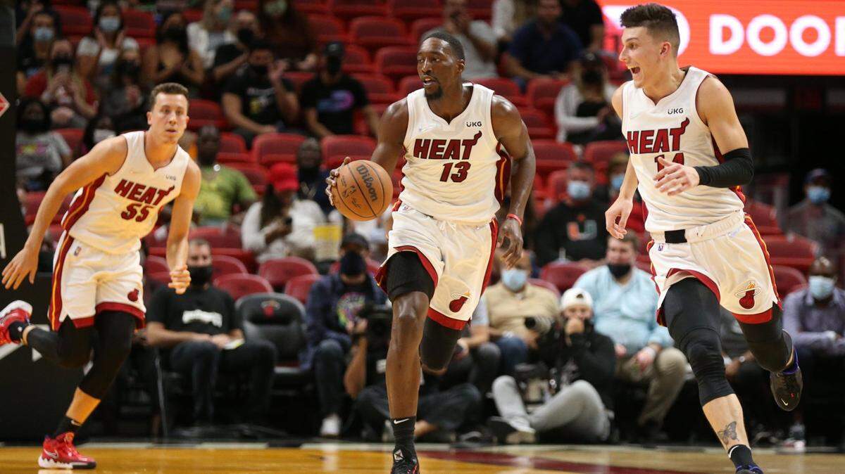 El centro del Heat Bam Adebayo lleva el balón escoltado por Duncan Robinson (55) y Tyler Herro en el partido contra los Celtics, el 15 de octubre.de 2021.