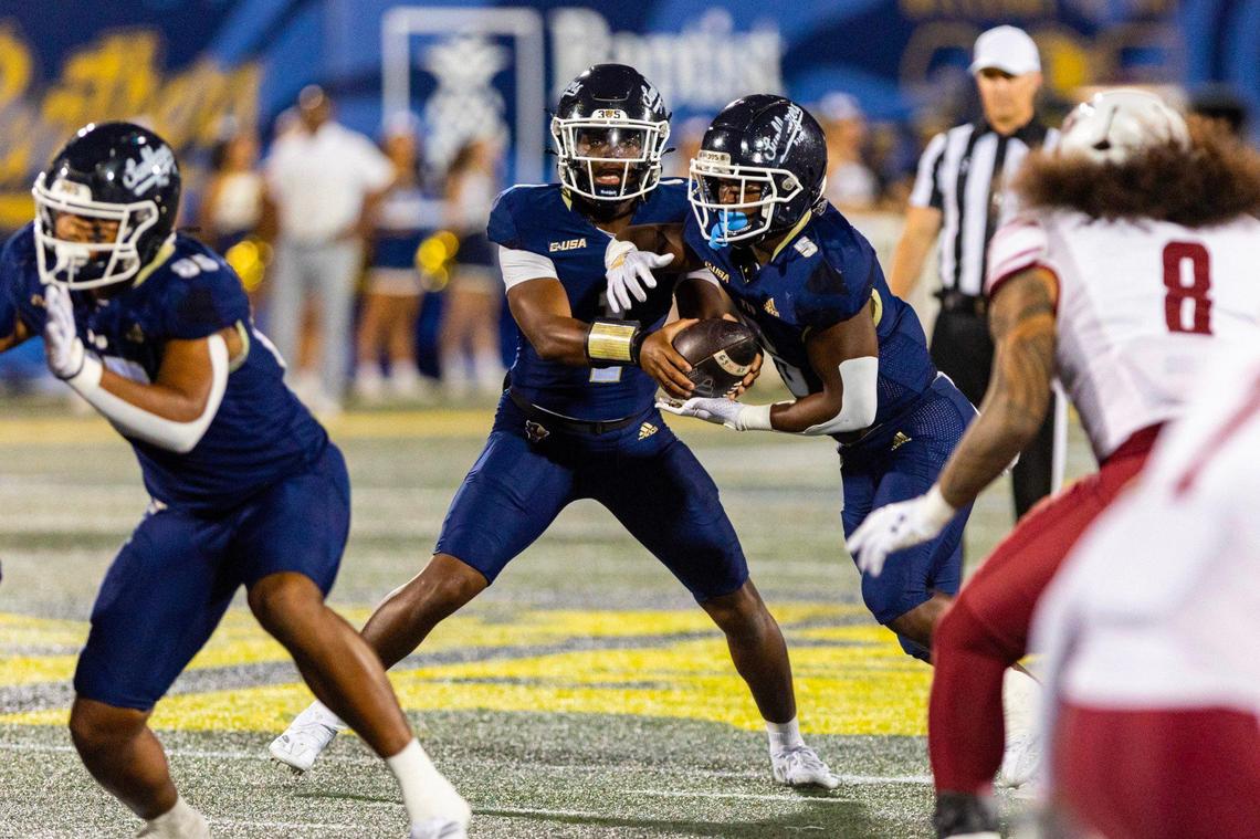 Florida International University Panthers quarterback Keyone Jenkins (1) hands the ball off to running back Kejon Owens (5) during the first half of an NCAA Conference USA football game against the New Mexico State Aggies at Pitbull Stadium on Tuesday, October 29, 2024, in Miami, Fla.