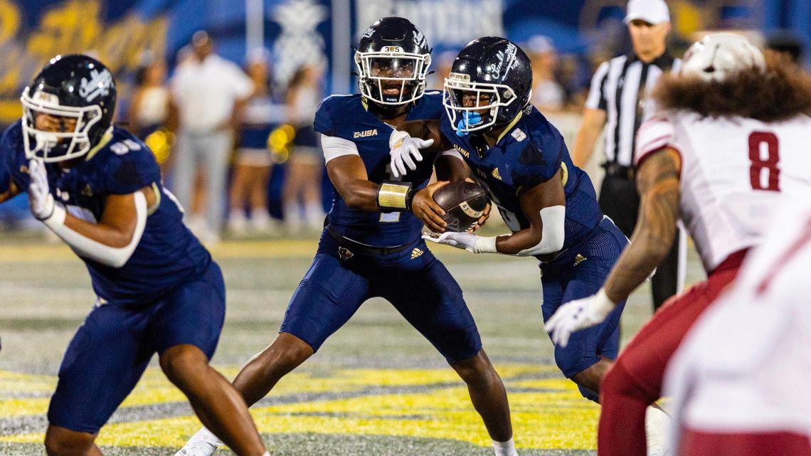 Florida International University Panthers quarterback Keyone Jenkins (1) hands the ball off to running back Kejon Owens (5) during the first half of an NCAA Conference USA football game against the New Mexico State Aggies at Pitbull Stadium on Tuesday, October 29, 2024, in Miami, Fla.