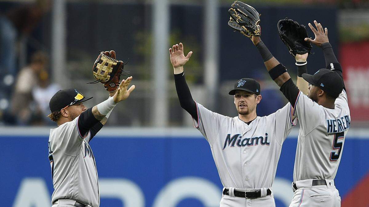 Miami Marlins center fielder Harold Ramirez, left, celebrates with Rosell Herrera,center, and JT Riddle after a baseball game against the San Diego Padres in San Diego, Sunday, June 2, 2019. The Marlins won 9-3. (AP Photo/Kelvin Kuo)