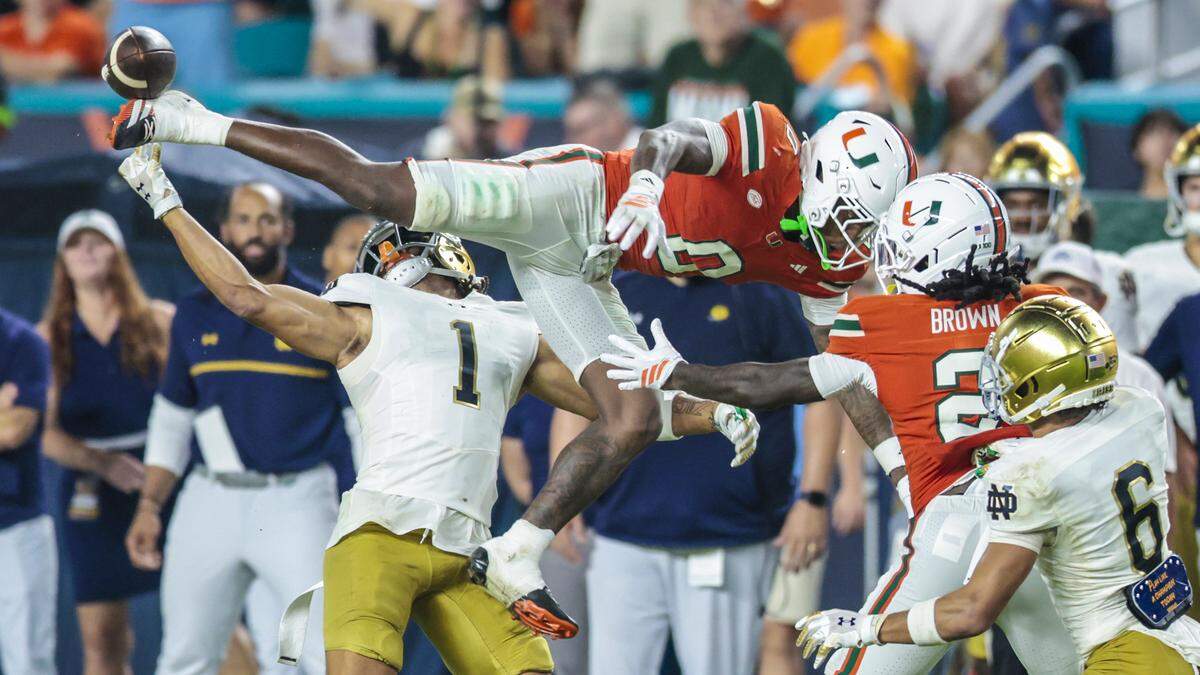 Miami Hurricanes defensive back Keionte Scott (0) defelcts a pass intended for Notre Dame Fighting Irish wide receiver Jaden Greathouse (1). Miami Hurricanes defensive lineman Rueben Bain Jr. (4) ends up picking up the interception in the fourth quarter during an NCAA football game at Hard Rock Stadium in Miami Gardens, Florida, on Sunday, August 31, 2025. 