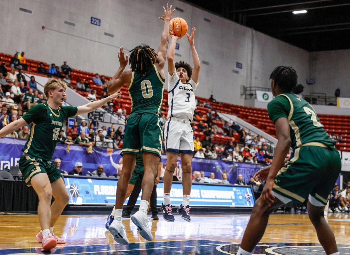 Calvary Christian Academy’s Cayden Daughtry (3) attempts to score over Villages defenders in the first half of the FHSAA Class 3A Boys High School Basketball State Championship at the RP Funding Center in Lakeland, Florida on Saturday, March 1, 2025.