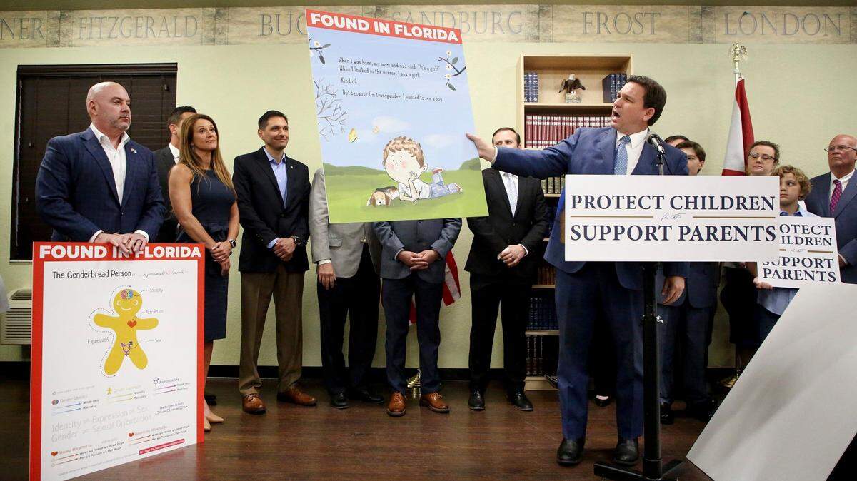 El gobernador Ron DeSantis muestra una imagen del libro infantil 'Call Me Max', del autor transexual Kyle Lukoff, momentos antes de promulgar el proyecto de ley de Derechos de los Padres en la Educación, durante una conferencia de prensa el 28 de marzo de 2022.