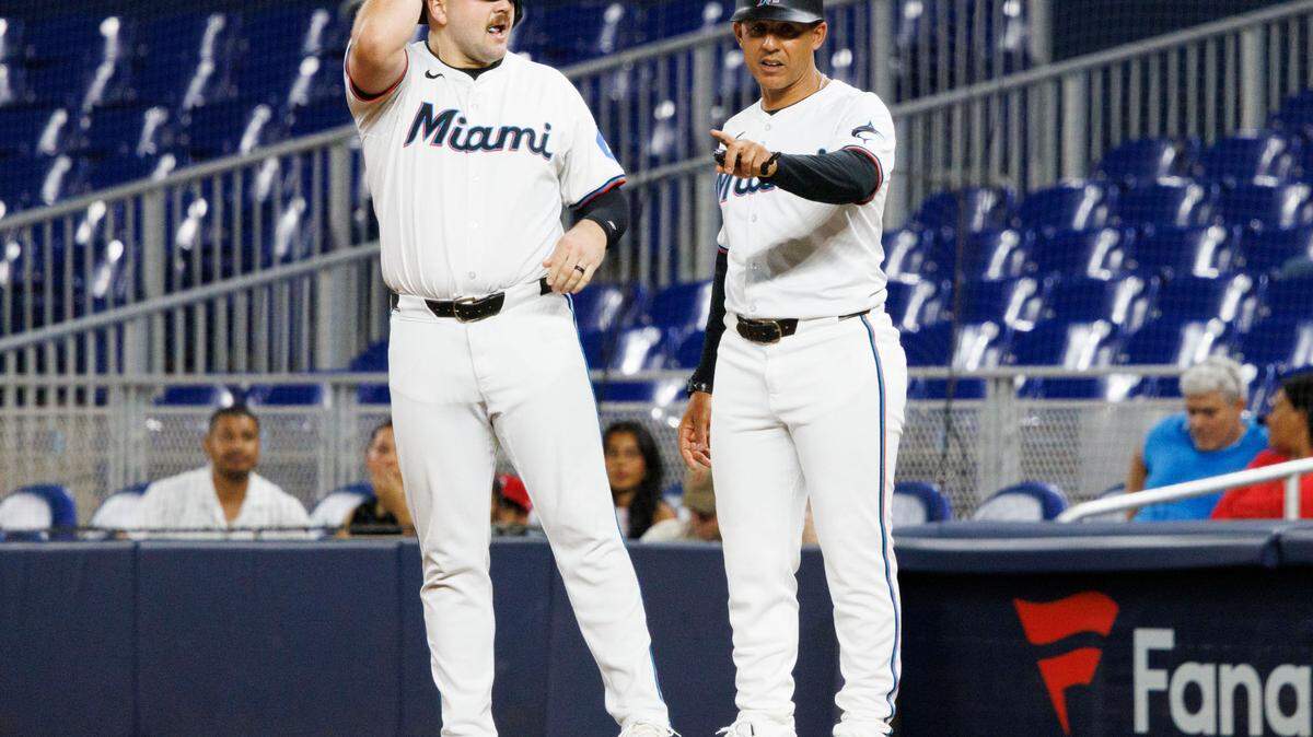Miami Marlins first base/outfield coach Jon Jay (11) talks to designated hitter Jake Burger (36) after he gets on base during the third inning of a baseball game on Tuesday, Sept. 3, 2024, at loanDepot Park in Miami.
