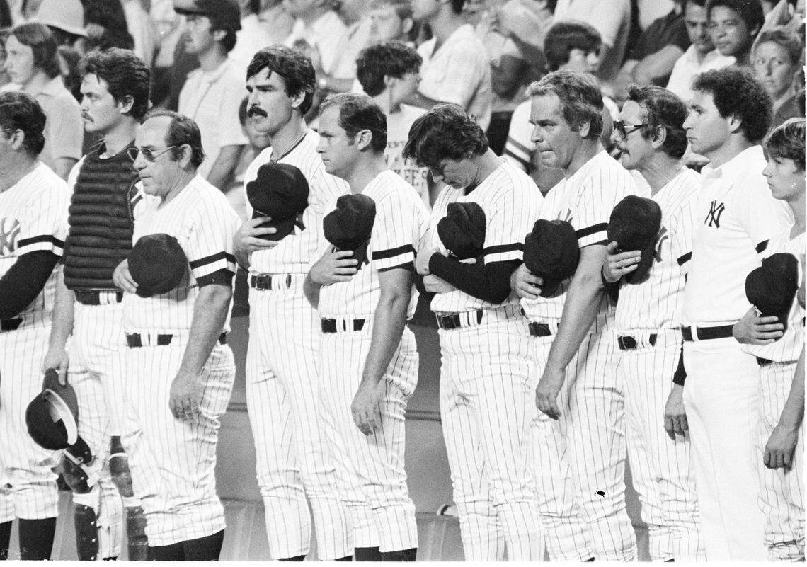 In this Aug. 3, 1979 file photo, New York Yankees line up on the dugout steps at New York’s Yankee Stadium, their sleeves wrapped in black arm bands, during a moment of silence Friday, for Yankees catcher Thurman Munson after he was killed in an airplane crash. From left are, catcher Jerry Narron, Yogi Berra, Don Hood, Mike Ferraro, Bobby Murcer, Charley Lau, and manager Billy Martin. During it’s 85 years, Yankee Stadium saw more momentous events than any other place the game has been played. (AP Photo/File)