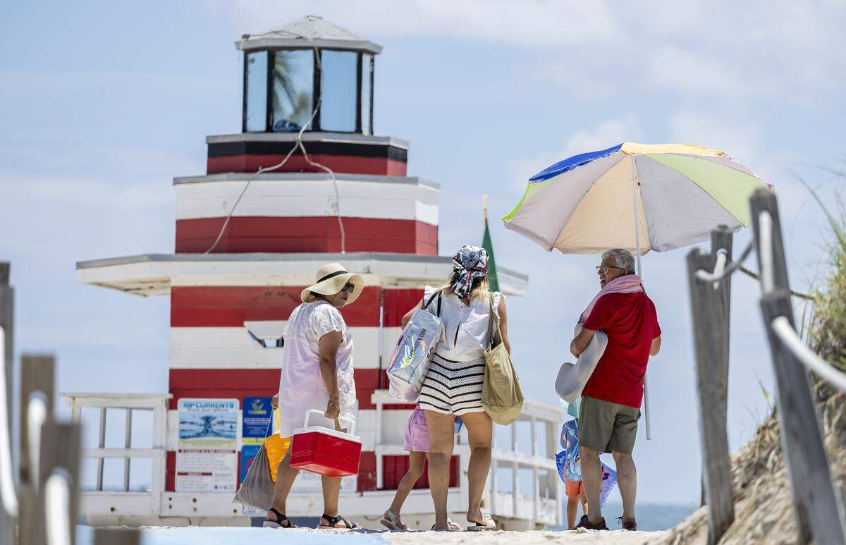 People arrive to South Beach as hot weather moves through the area on Friday, Aug. 15, 2025, in Miami Beach, Fla. Forecasters have issued heat advisories throughout the summer in South Florida, with temperatures at times feeling as hot as 109 degrees.