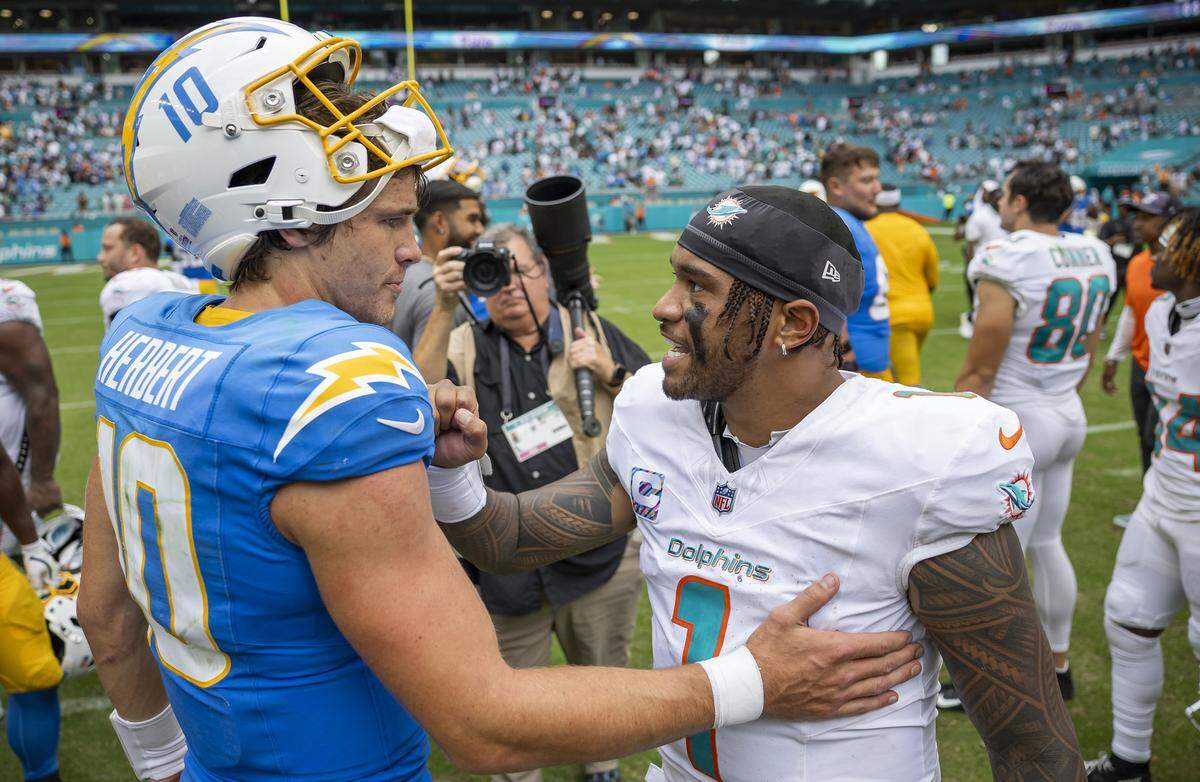 Miami Dolphins quarterback Tua Tagovailoa (1) greets Los Angeles Chargers quarterback Justin Herbert (10) after their NFL game at Hard Rock Stadium on Sunday, Oct. 12, 2025, in Miami Gardens, Fla.