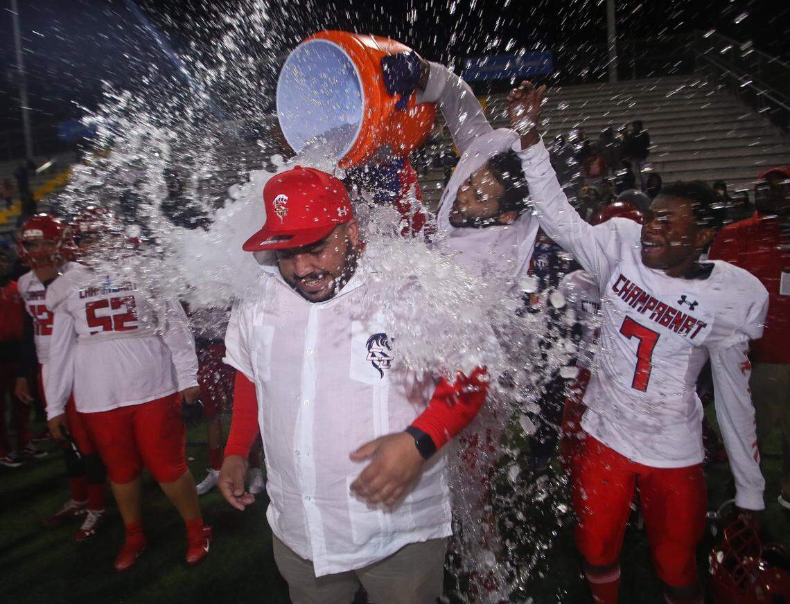 Champagnat Catholic head coach Hector Clavijo is doused with a water bath by lineman Ronaldo Sigers, in back, as wide receiver Cur’mari Dopson (7) celebrates at the conclusion of their FHSAA Class 2A Football State Championship against Lakeland Victory Christian Thursday, Dec.. 5, 2019 in Tallahassee, Fla. Champagnat Catholic won 35-14.
