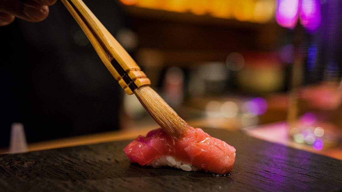 A chef brushes a piece of otoro (fatty tuna) at Sushi by Bou at the SLS in Brickell.