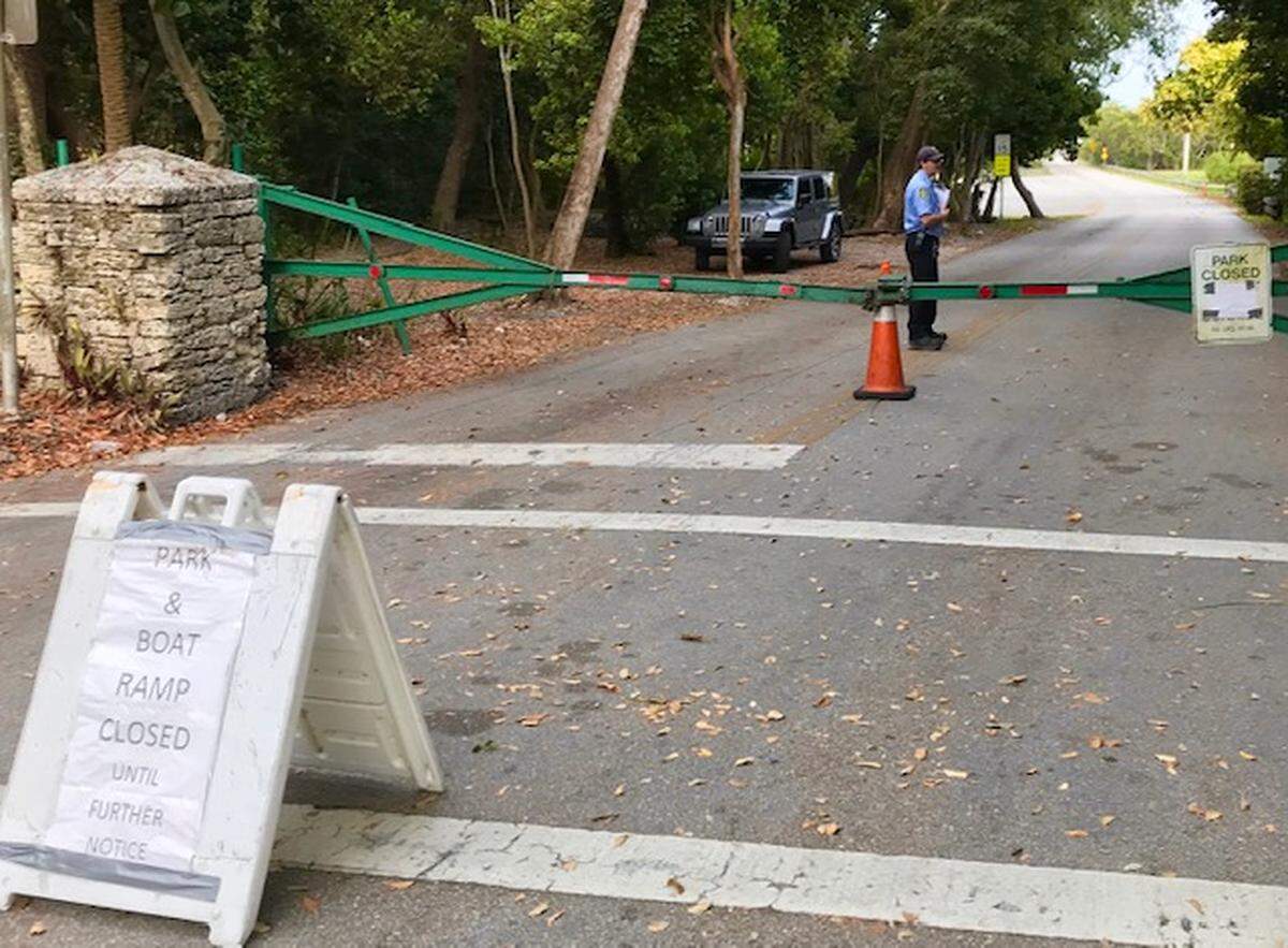 During the coronavirus pandemic, the entrance to Matheson Hammock Park is blocked, locked and monitored by a security guard.