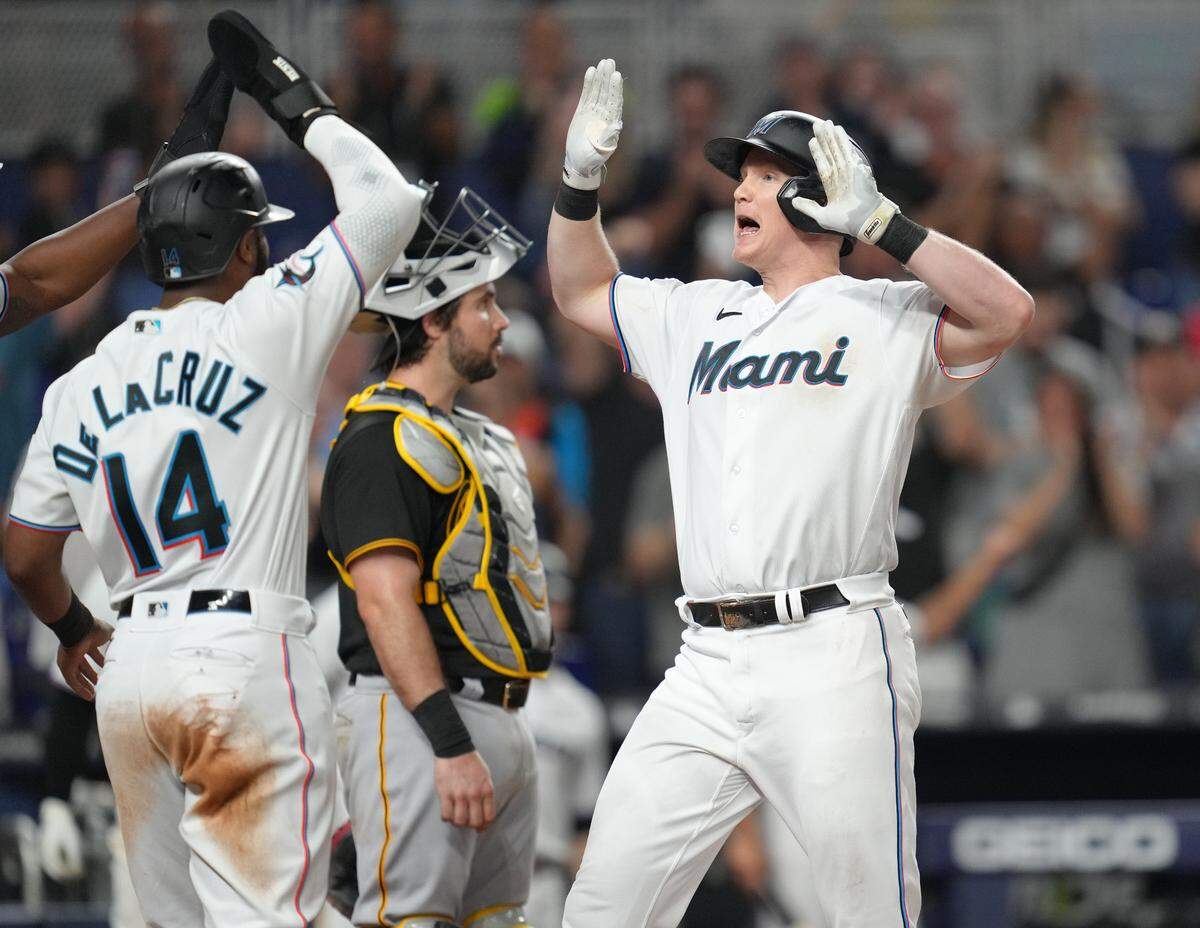 Jun 22, 2023; Miami, Florida, USA; Miami Marlins first baseman Garrett Cooper (26) celebrates a three-run home run in the eighth inning with left fielder Bryan De La Cruz (14) against the Pittsburgh Pirates at loanDepot Park. Mandatory Credit: Jim Rassol-USA TODAY Sports