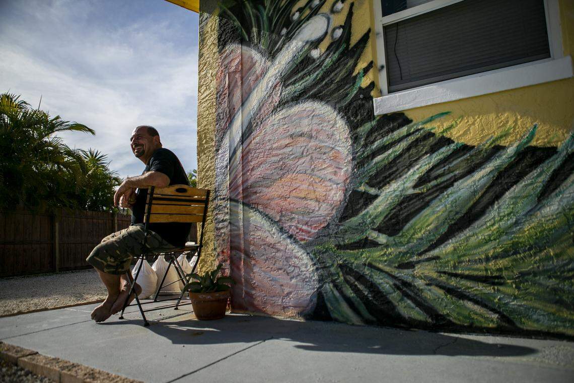 John Stasio, 53, has a drink outside his home after changing his mind about putting up storm shutters on Hutchinson Island in Fort Pierce on Friday, August 30, 2019.
