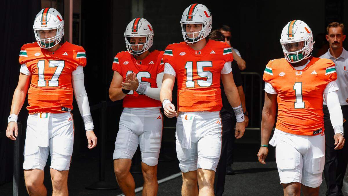 Miami Hurricanes quarterbacks Emory Williams (17) Reese Poffenbarger (16) quarterback Judd Anderson (15) and Cam Ward (1) arrive for warmup before the NCAA football game against the Ball State Cardinals at Hard Rock Stadium in Miami Gardens, Florida on Saturday, September 14, 2024.