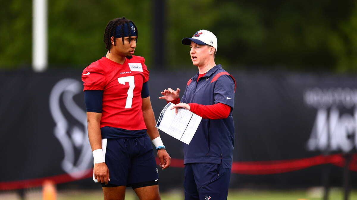 Texans offensive coordinator Bobby Slowik speaks with rookie quarterback C.J. Stroud during practice.