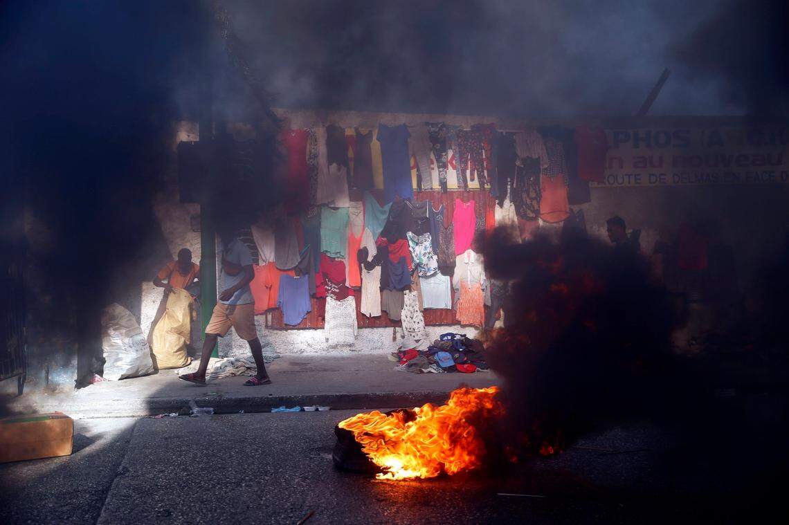 Smoke from tires set on fire by protesters fills a street in Delmas, where vendors sell clothing, during a countrywide transportation strike protesting rising insecurity and ransom kidnappings in Haiti Monday, Feb. 1, 2021. Opposition leaders are pushing for President Jovenel Moïse to step down on Feb. 7 while Moïse has said his term ends in February 2022.