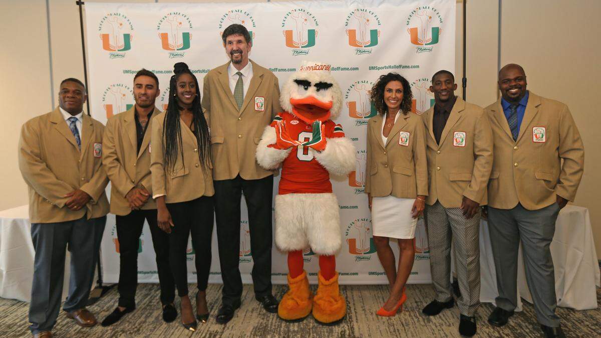 From left to right, Former University of Miami Hurricanes students athlete Stephen McGuire, Cesar Carrillo, Tabia Charles Collins, Constantin Popa, Jenny Krawec, Antrel Rolle and Vince Wilfork pose for a photo alongside Sebastian the Ibis before being inducted into the University of Miami Sports Hall of Fame at the induction ceremony Thursday night, April 2, 2019, at Jungle Island.